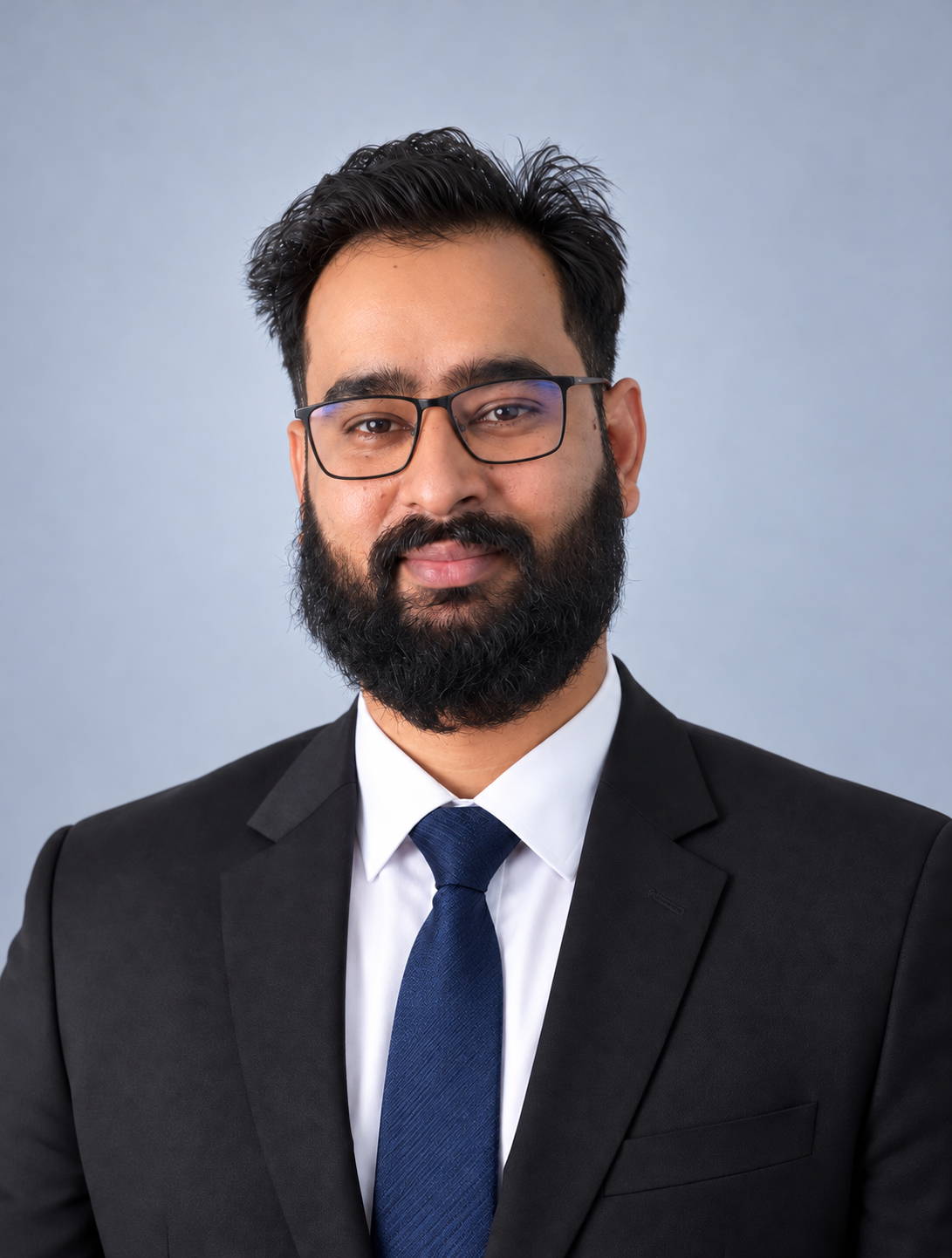 Shah Zaib wearing glasses and a dark suit